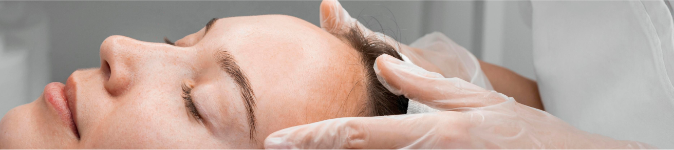 Zbliżenie na twarz kobiety podczas zabiegu kosmetologicznego – dłonie specjalisty w rękawiczkach