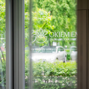 Wejście do Kliniki Dr Frąszczak – logotyp i godziny otwarcia na szybie